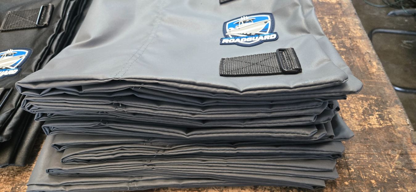 Finished Marine RoadGuard shields stacked on production table